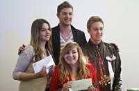 A group of teenagers standing and holding up envelopes